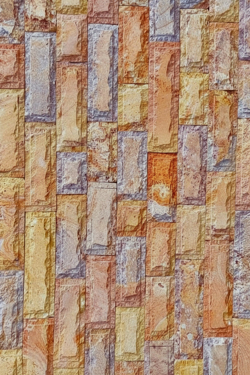 Cintilla Arcoíris de cantera natural decorativa con textura rugosa y tonos tierra, ideal para acabados arquitectónicos.