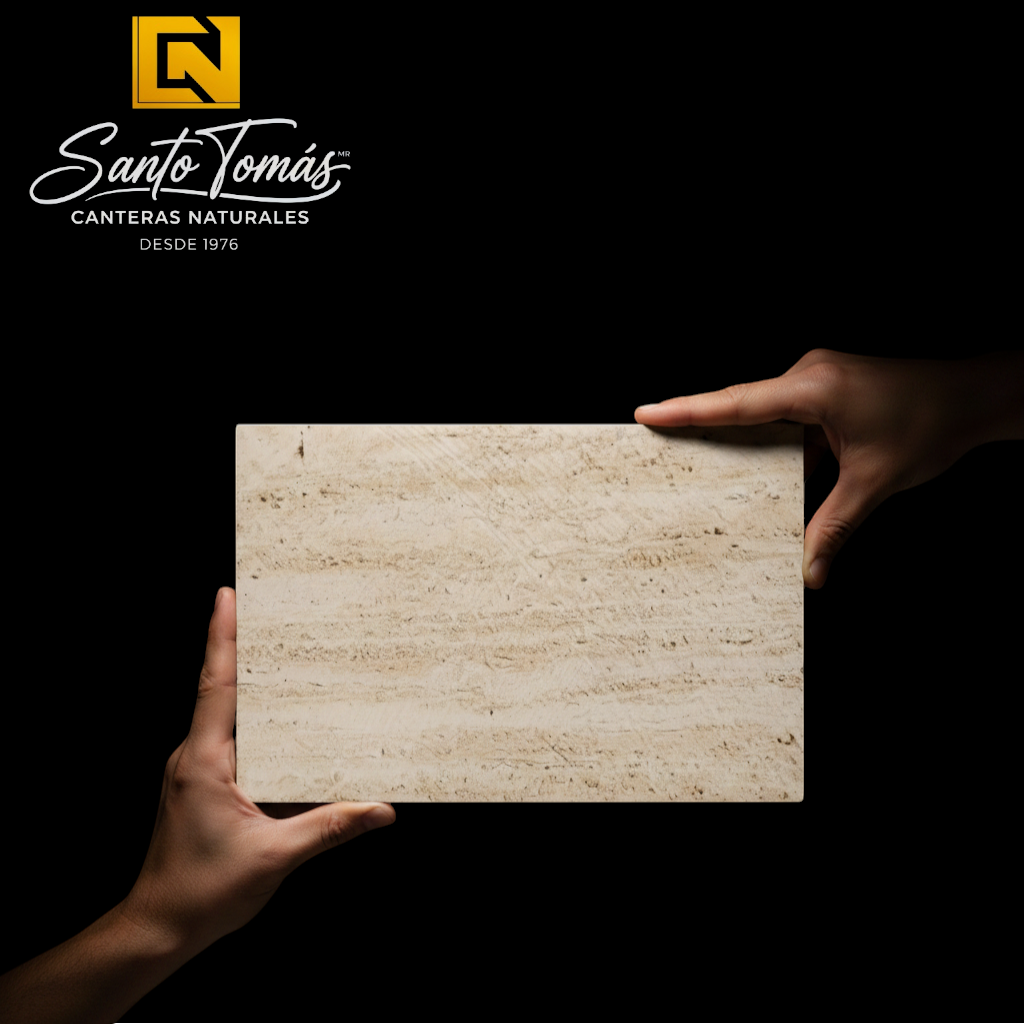 Hands holding a Canteras Naturales Santo Tomás Cantera Beige Rivera stone tile with a natural granular texture.