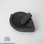 Molcajete de basalto con forma de hoja, vista superior cenital, mostrando el interior del cuenco y el patrón de vetas talladas artesanalmente