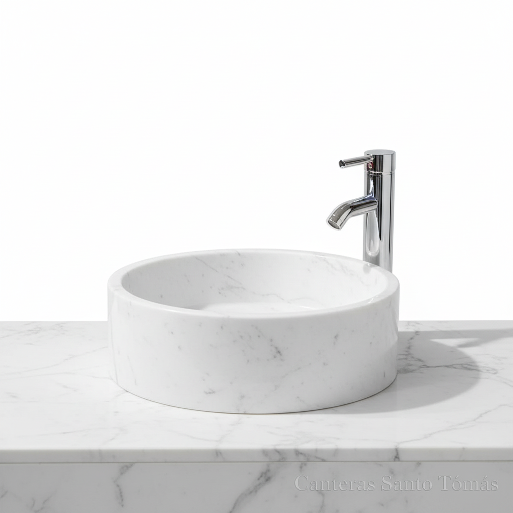 Lavabo ovalín redondo artesanal de mármol Blanco Bego natural de 40 cm con grifo cromado sobre encimera.