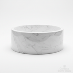 Lavabo ovalín redondo artesanal en mármol blanco Bego de 40 cm con acabado pulido y vetas naturales sobre fondo blanco.